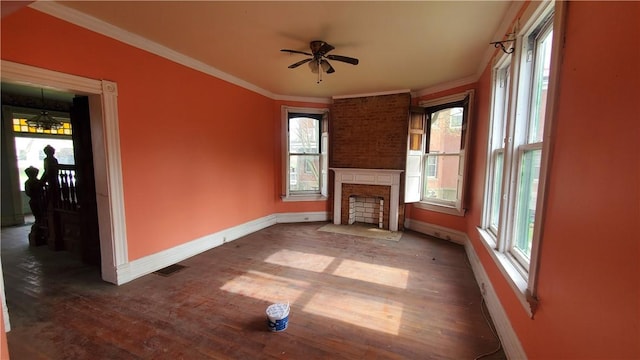 unfurnished living room featuring baseboards, wood finished floors, a ceiling fan, crown molding, and plenty of natural light