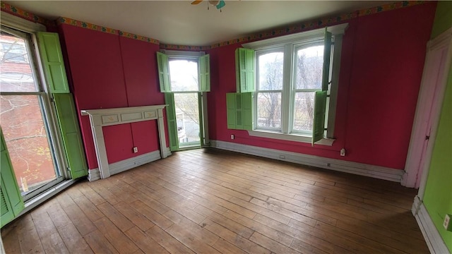 unfurnished living room with healthy amount of natural light and baseboards