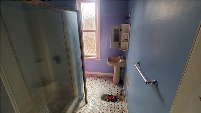 bathroom with a stall shower, baseboards, and tile patterned floors