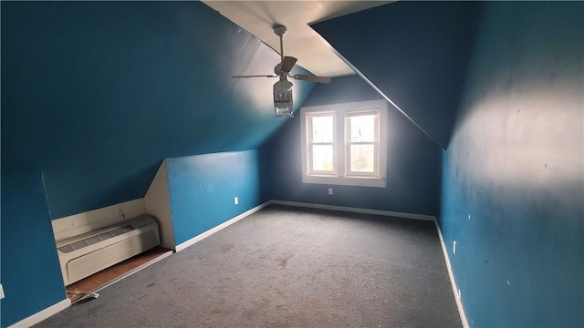 additional living space with an AC wall unit, a ceiling fan, vaulted ceiling, baseboards, and carpet floors