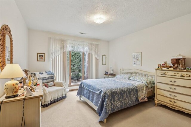 carpeted bedroom featuring a textured ceiling
