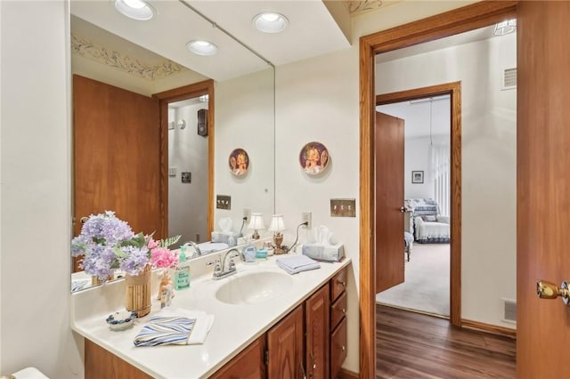bathroom featuring wood finished floors, vanity, and recessed lighting