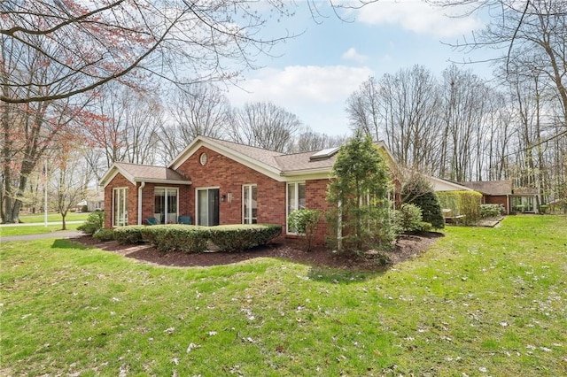 view of side of home featuring brick siding and a yard