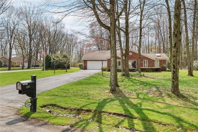 view of front of home with brick siding, a front yard, and driveway