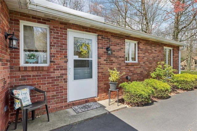view of exterior entry with brick siding