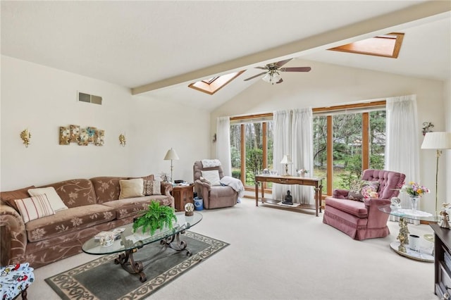 living room with a skylight, carpet floors, beam ceiling, a ceiling fan, and high vaulted ceiling