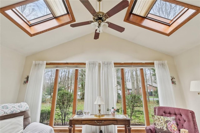 living area with a skylight, lofted ceiling, and ceiling fan