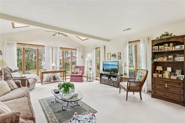 living room with carpet, lofted ceiling, healthy amount of natural light, a skylight, and ceiling fan