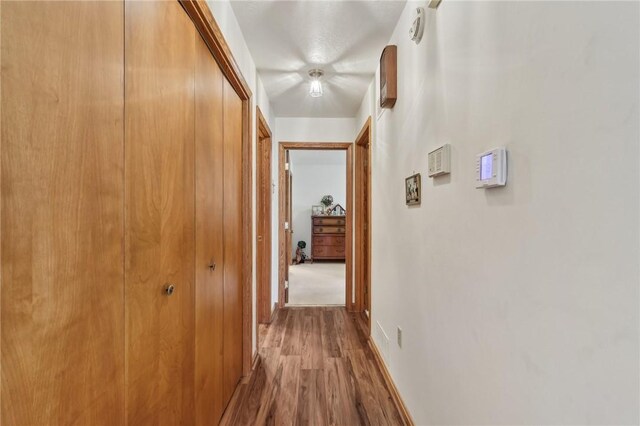 hallway with wood finished floors and baseboards