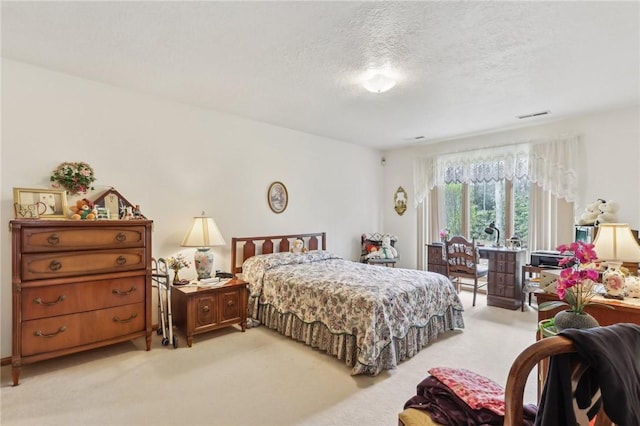 bedroom with light colored carpet, a textured ceiling, and access to outside