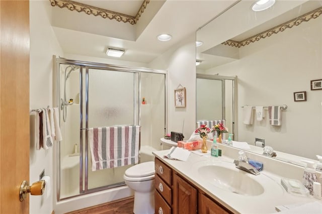 full bathroom featuring a shower stall, wood finished floors, toilet, vanity, and recessed lighting
