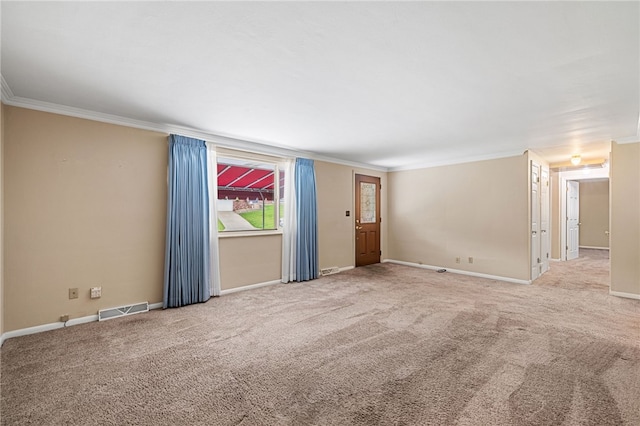empty room with crown molding, carpet, and baseboards