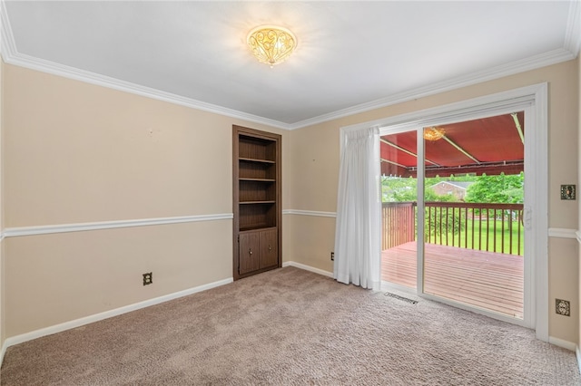 carpeted spare room featuring crown molding and baseboards