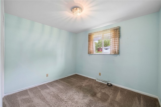 carpeted empty room featuring baseboards