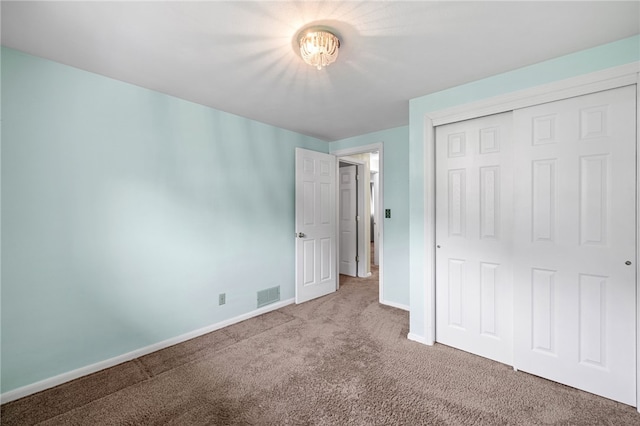 unfurnished bedroom with carpet flooring, baseboards, and a closet