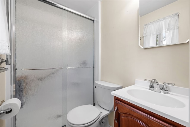 bathroom featuring a stall shower, vanity, and toilet