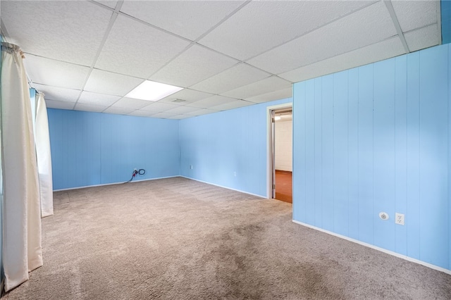 carpeted spare room with a paneled ceiling