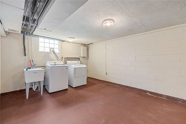 below grade area featuring separate washer and dryer, baseboards, and a sink
