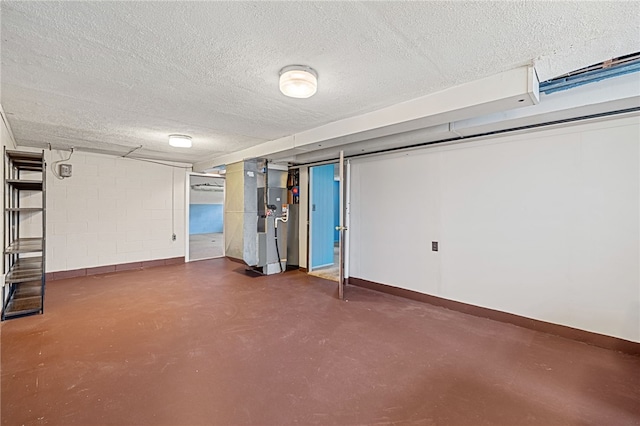 finished basement featuring a textured ceiling, baseboards, and heating unit