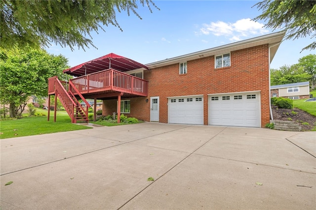 view of front of house featuring a garage, driveway, a wooden deck, brick siding, and stairway