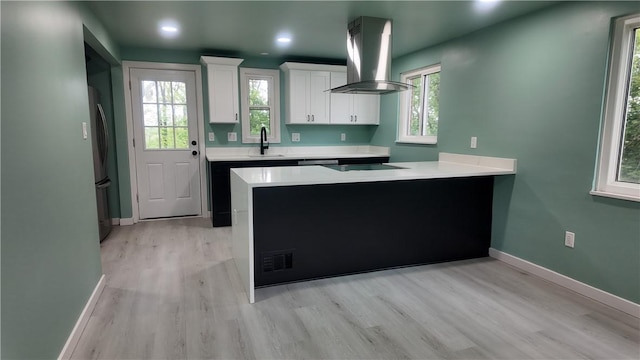 7709 Mark Dr, Penn Hills, PA 15147 - kitchen featuring wall chimney exhaust hood, a sink, white cabinets, light countertops, and light wood-style flooring