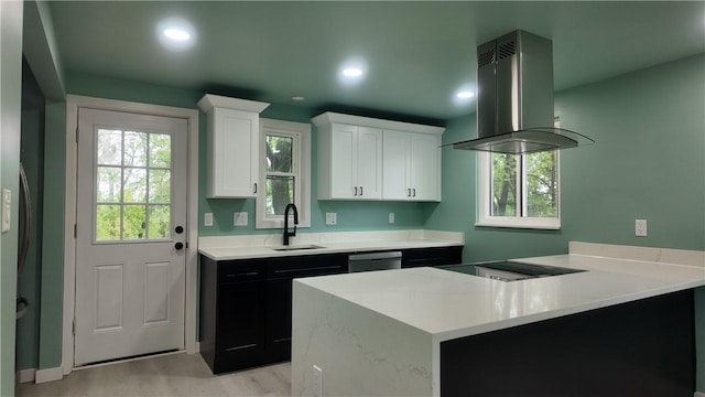 7709 Mark Dr, Penn Hills, PA 15147 - kitchen featuring island exhaust hood, stovetop, white cabinetry, a sink, and light wood-type flooring