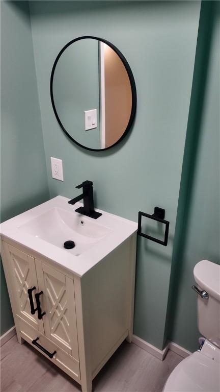7709 Mark Dr, Penn Hills, PA 15147 - half bath featuring wood finished floors, vanity, toilet, and baseboards