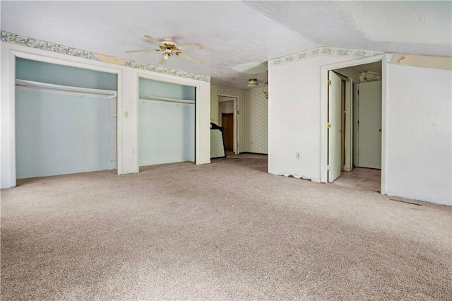 1035 Rte 130, City Of Greensburg, PA 15601 - unfurnished bedroom featuring carpet flooring, multiple closets, a textured ceiling, ceiling fan, and lofted ceiling