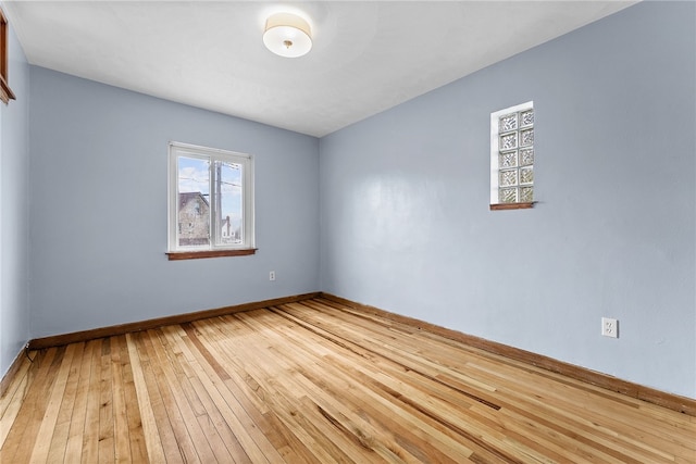 spare room featuring hardwood / wood-style flooring and baseboards