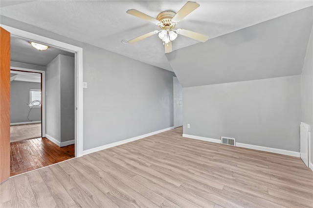 additional living space with wood finished floors, ceiling fan, baseboards, and lofted ceiling