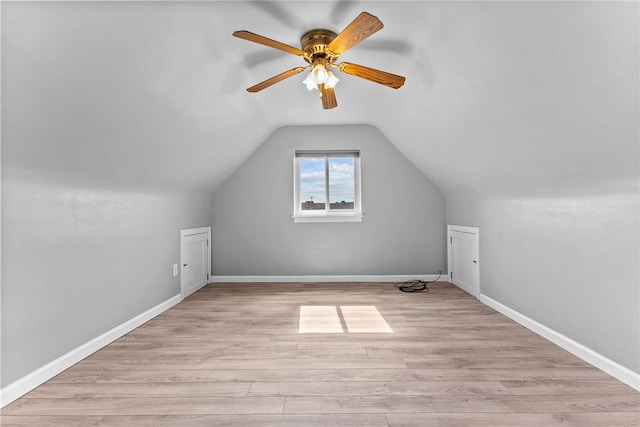 additional living space with ceiling fan, light wood-type flooring, vaulted ceiling, and baseboards