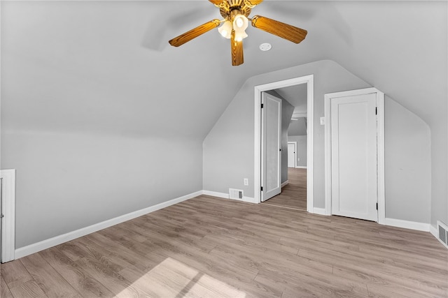 additional living space with a ceiling fan, wood finished floors, vaulted ceiling, and baseboards