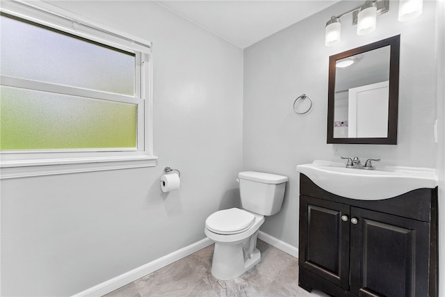 half bath featuring baseboards, toilet, vanity, and marble finish flooring