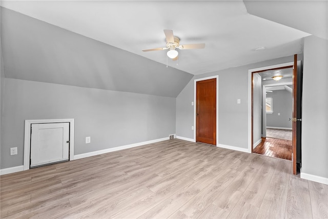 additional living space featuring ceiling fan, lofted ceiling, light wood-style flooring, and baseboards