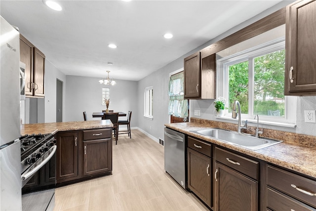 kitchen featuring appliances with stainless steel finishes, a sink, plenty of natural light, dark brown cabinetry, and recessed lighting