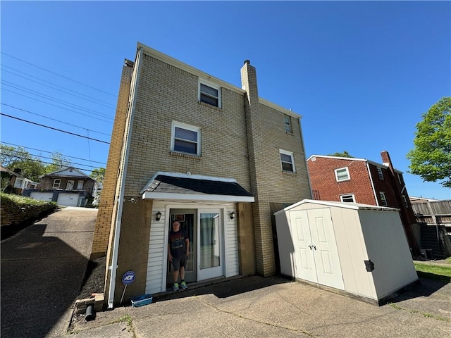 286 Brighton St, Chalfant Boro, PA 15112 - rear view of property featuring a storage shed, an outbuilding, a chimney, and brick siding