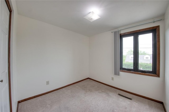 spare room featuring carpet flooring and baseboards