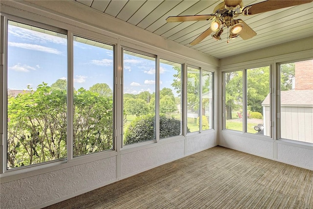 unfurnished sunroom with a ceiling fan and plenty of natural light