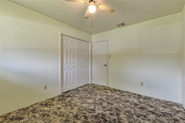 unfurnished bedroom with carpet floors, a closet, and a ceiling fan