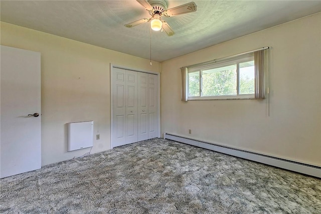 unfurnished bedroom with baseboard heating, carpet, a closet, and a ceiling fan