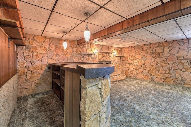bar area with a paneled ceiling, carpet floors, and hanging light fixtures