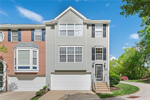 townhome / multi-family property with an attached garage and concrete driveway