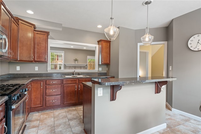 kitchen with stainless steel appliances, a kitchen breakfast bar, a sink, light tile patterned floors, and a center island