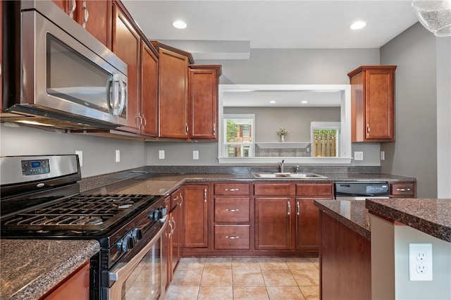 kitchen featuring stainless steel appliances, a sink, light tile patterned flooring, recessed lighting, and brown cabinets