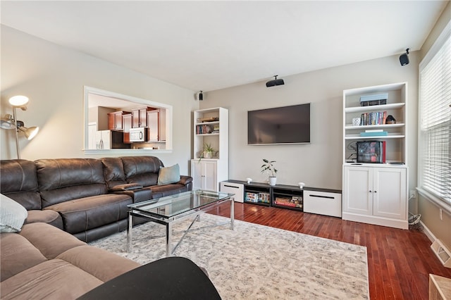 living area with dark wood-style flooring and baseboards