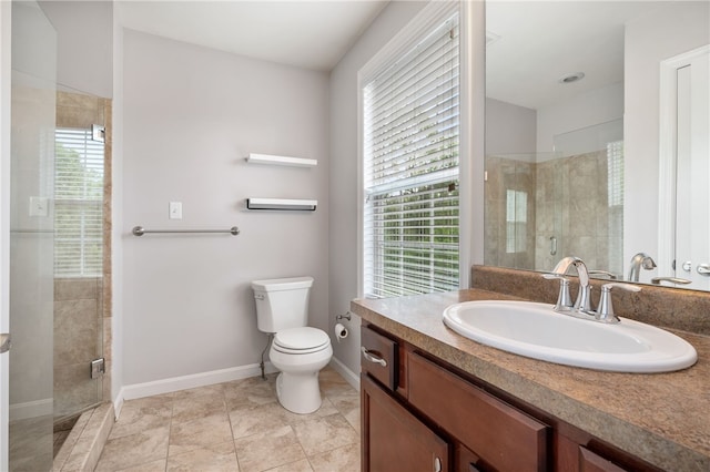 full bathroom featuring a stall shower, toilet, baseboards, and vanity