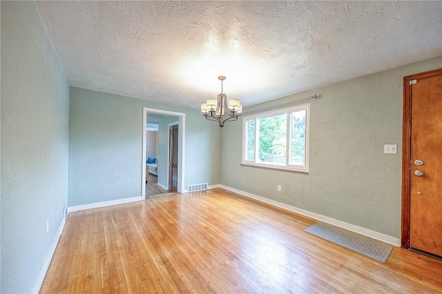 140 8th Ave, Ross Twp, PA 15229 - empty room featuring a chandelier, a textured wall, light wood-style flooring, a textured ceiling, and baseboards