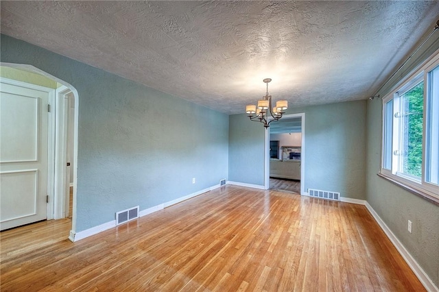 140 8th Ave, Ross Twp, PA 15229 - unfurnished room with wood finished floors, a chandelier, plenty of natural light, a textured ceiling, and a textured wall