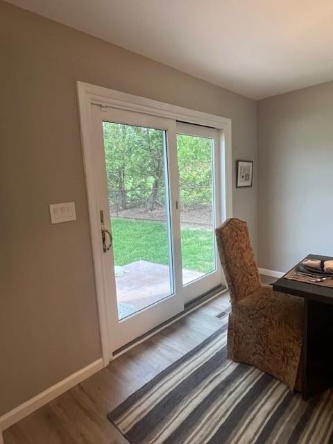 doorway to outside featuring baseboards and wood finished floors