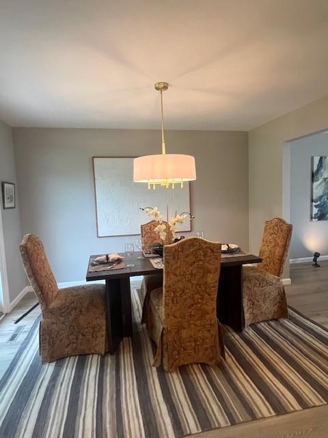dining area with baseboards and dark wood-style floors
